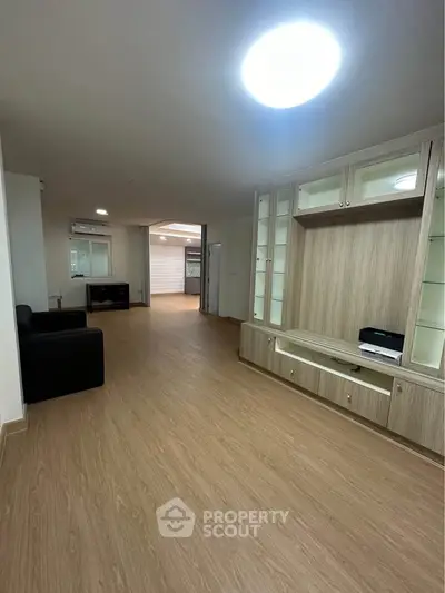 Spacious living room with modern wooden flooring and built-in storage unit