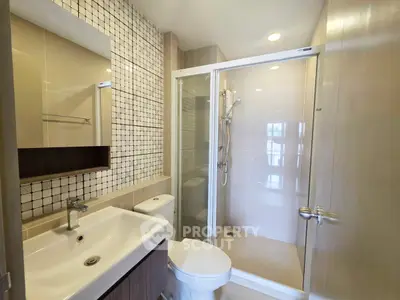Modern bathroom with sleek shower and stylish sink in contemporary apartment.