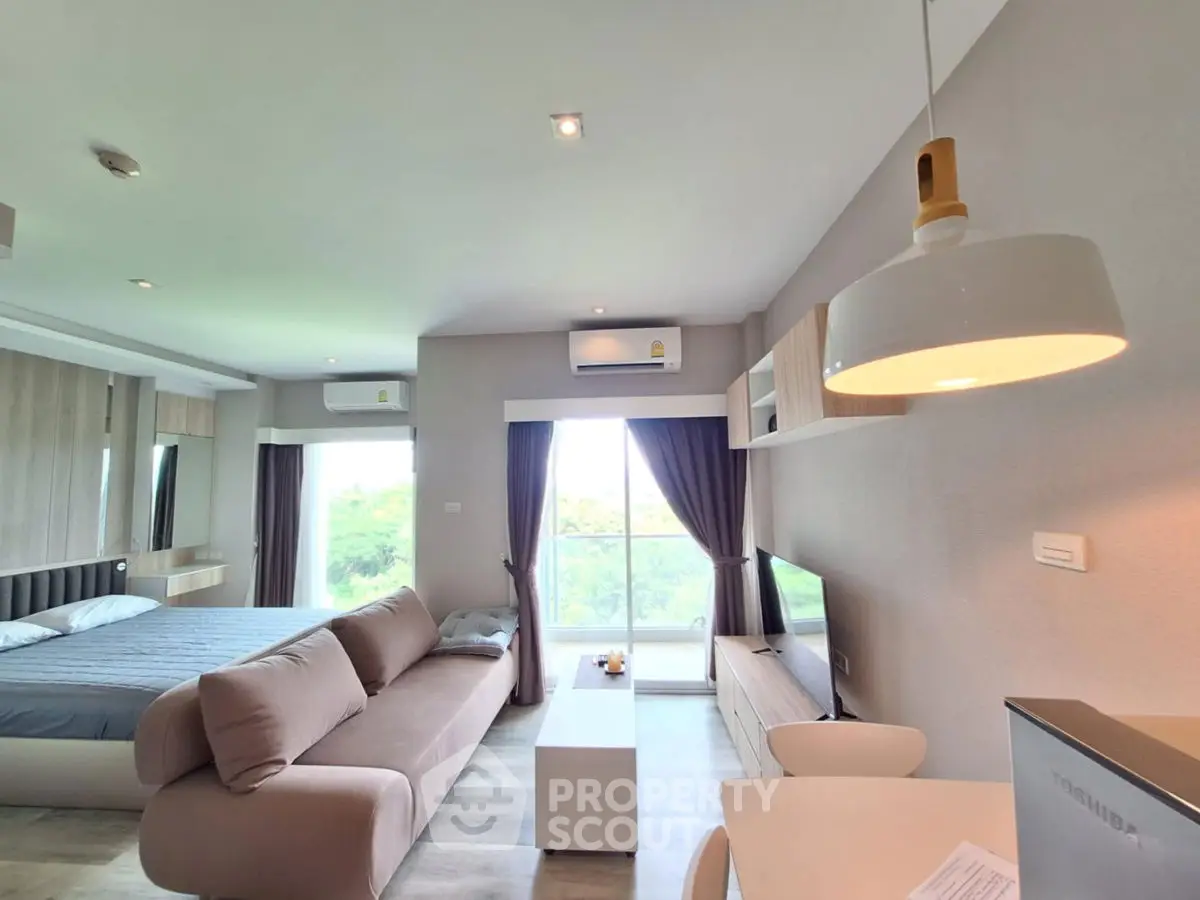 Modern studio apartment with stylish decor, featuring a cozy living area and a comfortable bed.