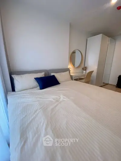 Cozy bedroom with modern decor and a large bed, perfect for relaxation.
