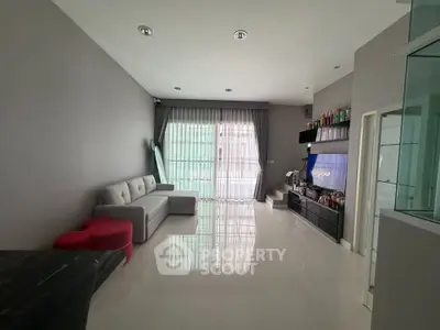 Modern living room with sleek furniture and large window for natural light.