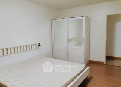 Spacious bedroom with wooden flooring and modern wardrobe