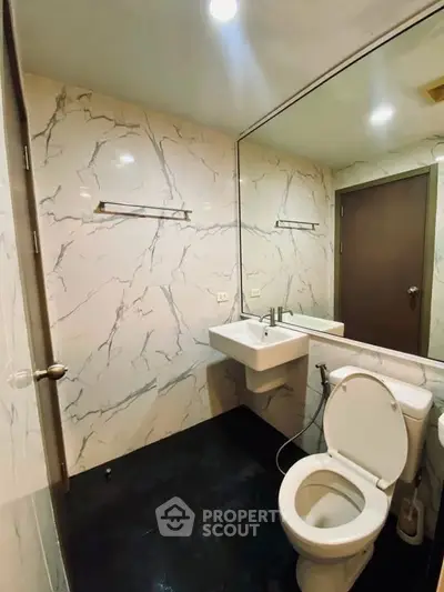 Modern bathroom with marble walls and sleek fixtures in a contemporary apartment.