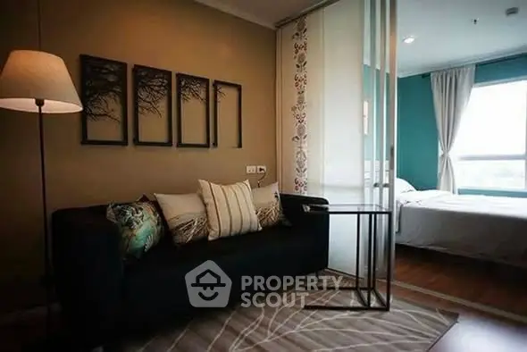 Modern living room with stylish decor and sliding glass door leading to a cozy bedroom.