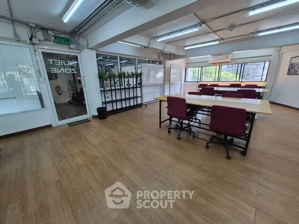 Spacious office space with modern furnishings and large windows for natural light.