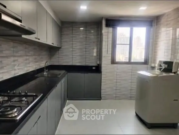 Modern kitchen with sleek cabinetry and gas stove in a high-rise apartment.