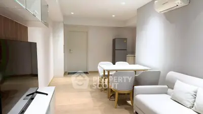 Modern living room with sleek furniture and open layout, featuring a cozy dining area and air conditioning.