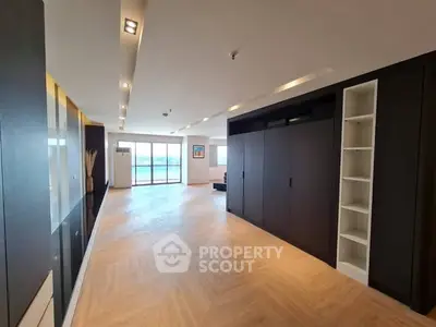 Spacious modern living room with elegant wood flooring and large windows offering stunning views.