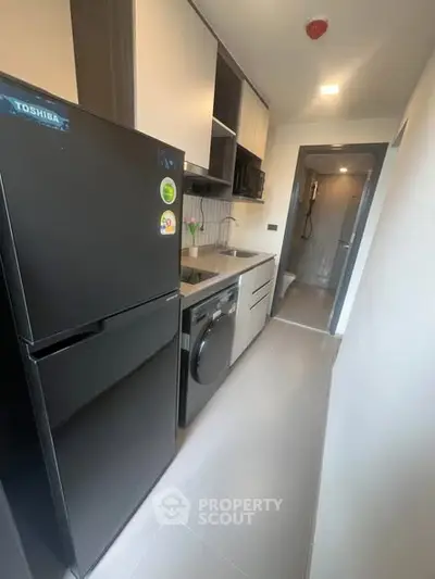 Modern kitchen with sleek appliances and compact design in a contemporary apartment.