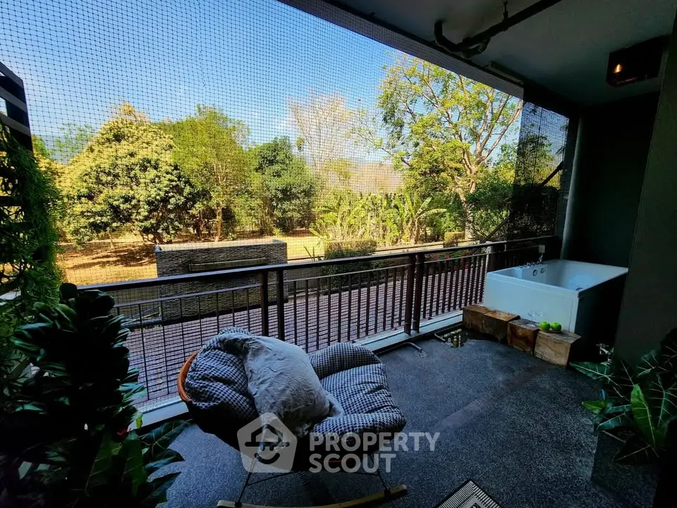 Spacious balcony with garden view and outdoor bathtub, perfect for relaxation.
