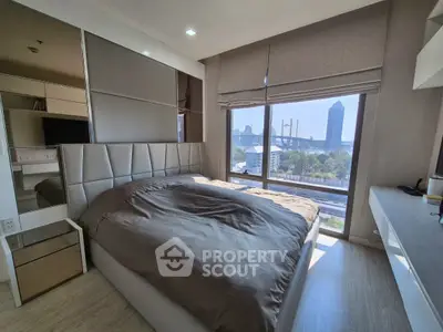 Modern bedroom with large window offering stunning city view and stylish decor.