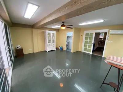 Spacious living room with modern ceiling fan and ample natural light