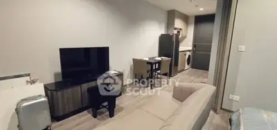 Modern living room with sleek furniture and open kitchen layout in a stylish apartment.