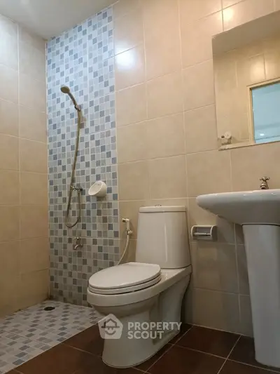 Modern bathroom with tiled shower and sleek fixtures in a contemporary home.