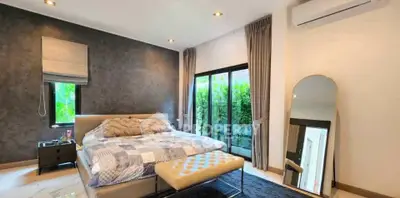 Luxurious bedroom with modern decor, large windows, and stylish furnishings.