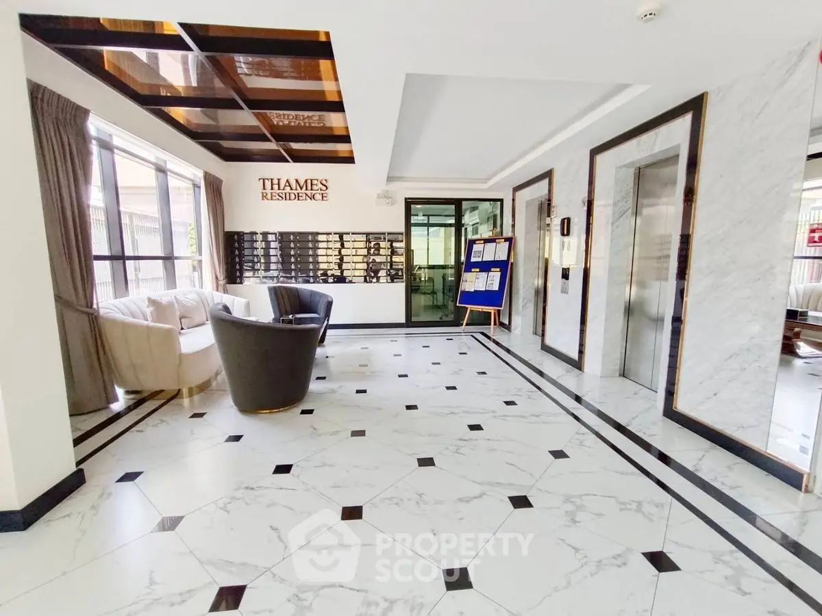Luxurious building entrance with marble flooring and modern elevators at Thames Residence.