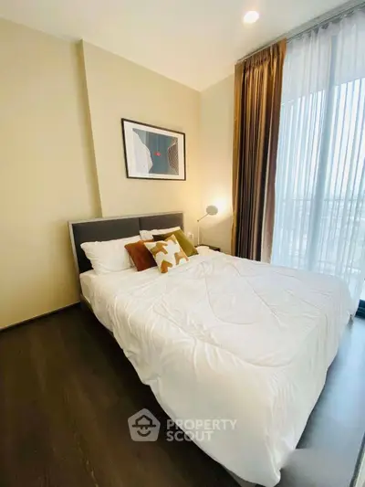 Cozy bedroom with modern decor and large window for natural light