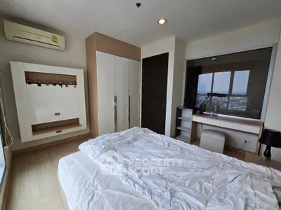 Spacious bedroom with modern decor and city view, featuring a cozy bed and ample storage space.