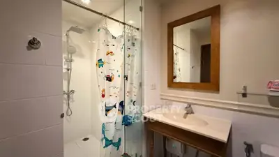 Charming bathroom with modern shower and playful curtain in cozy real estate property.