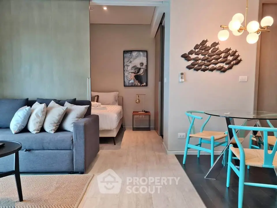 Modern open-plan living room with stylish decor and cozy bedroom view.