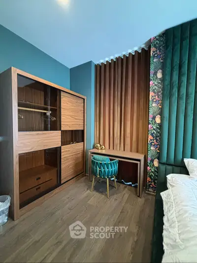 Stylish bedroom with modern decor, featuring a wooden wardrobe and elegant chair.