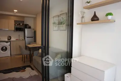 Modern apartment interior with open kitchen and cozy living area, featuring stylish decor and appliances.