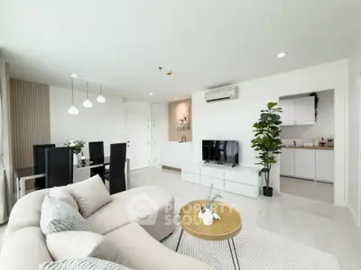 Spacious modern living room with elegant dining area and open kitchen layout, featuring stylish decor and ample natural light.