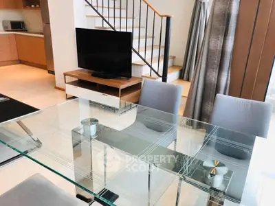 Modern living room with glass dining table and staircase in stylish apartment