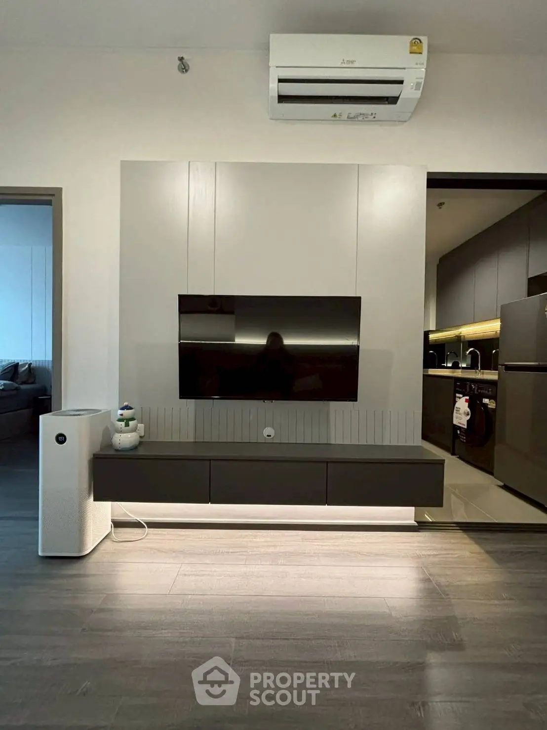 Modern living room with sleek TV setup and air conditioning unit.
