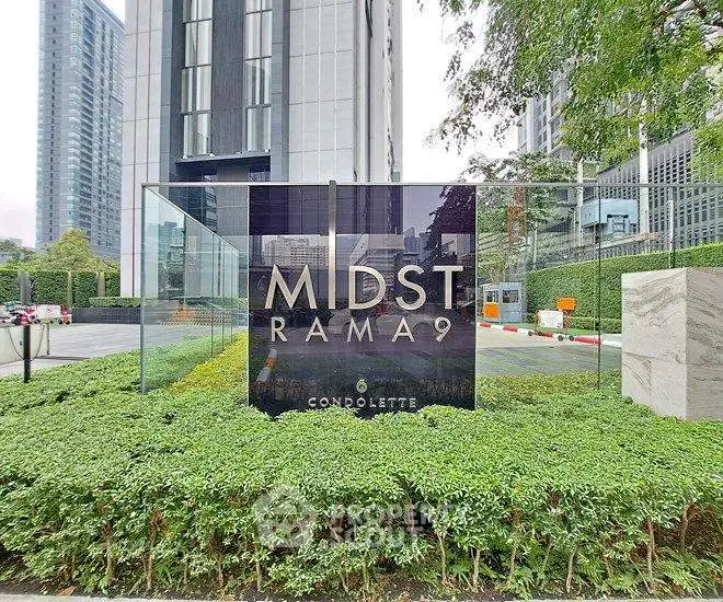 Modern condominium entrance with sleek design and lush greenery at Midst Rama 9.