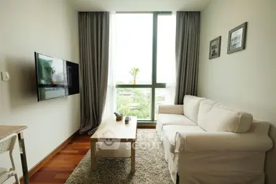 Modern living room with cozy sofa and large window offering a scenic view, perfect for relaxation.