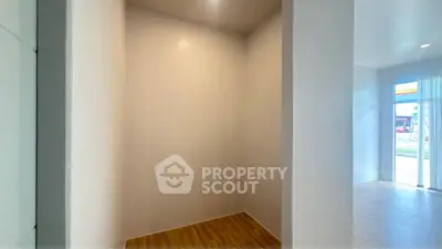 Spacious interior corner with wooden flooring and natural light, ideal for creative design.