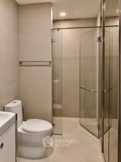 Modern bathroom with glass shower and sleek fixtures in a contemporary apartment.