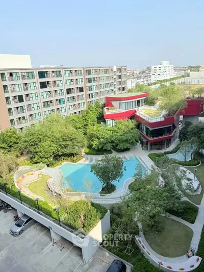 Stunning aerial view of modern apartment complex with lush gardens and inviting pool area.