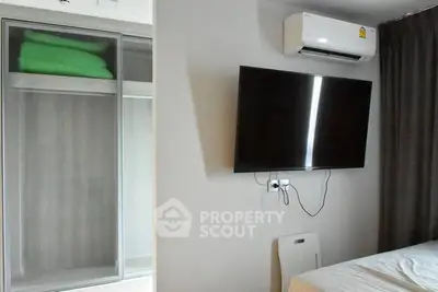 Modern bedroom with wall-mounted TV and air conditioning unit
