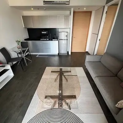 Modern living room with sleek kitchen and stylish furniture in open layout.