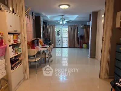 Spacious living room with dining area and large windows, featuring modern furniture and bright lighting.