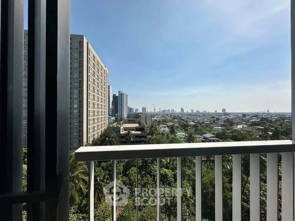 Stunning cityscape view from a high-rise balcony overlooking lush greenery and urban skyline.