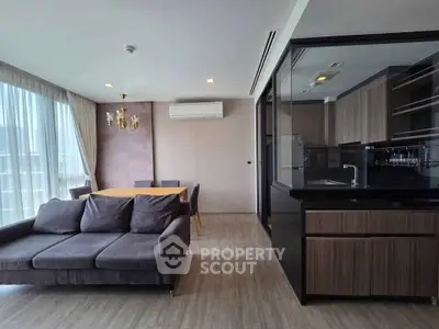Modern living room with elegant dining area and sleek kitchen design.