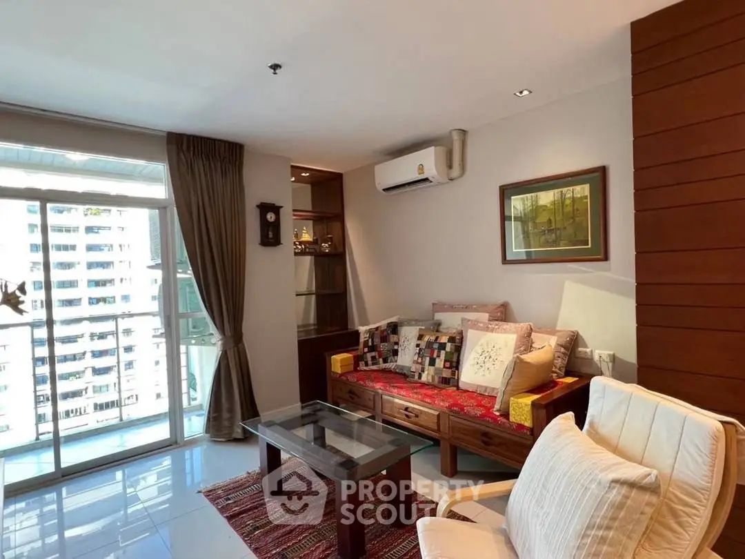 Charming living room with cozy seating and city view balcony