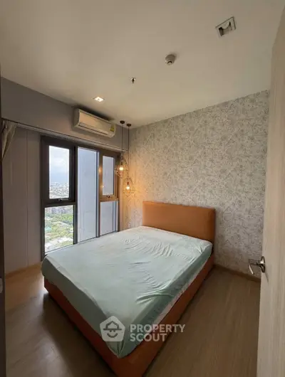 Modern bedroom with large window and stylish lighting in a high-rise apartment.