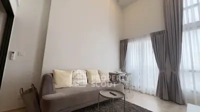 Modern living room with high ceilings and elegant decor in a stylish apartment.