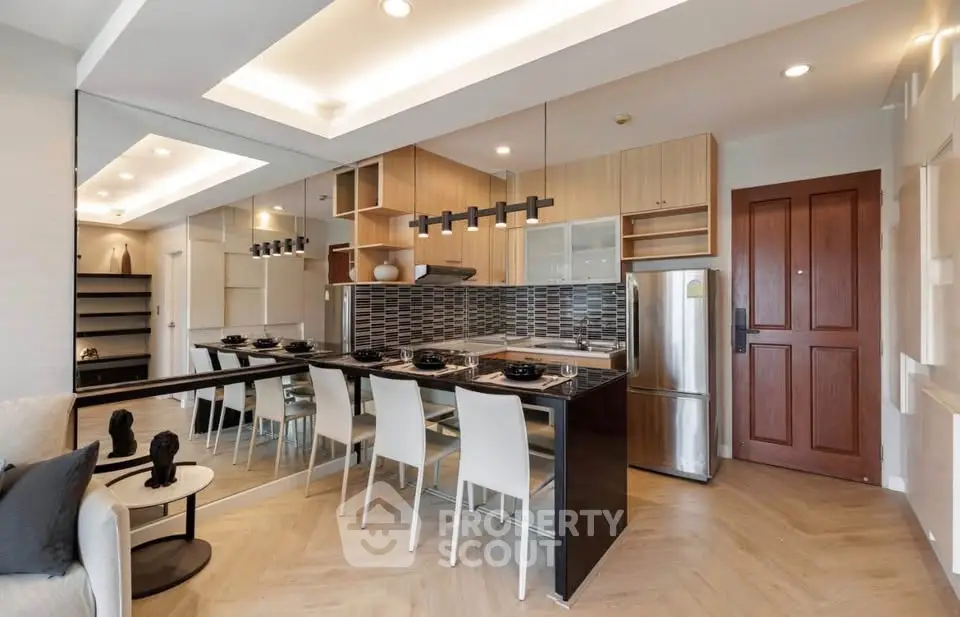 Modern open-layout kitchen with sleek design and dining area, featuring stylish lighting and contemporary decor.