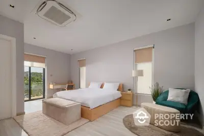 Spacious bedroom with modern design, large bed, elegant furniture, and access to a sunlit balcony with a serene view, perfect for relaxation.