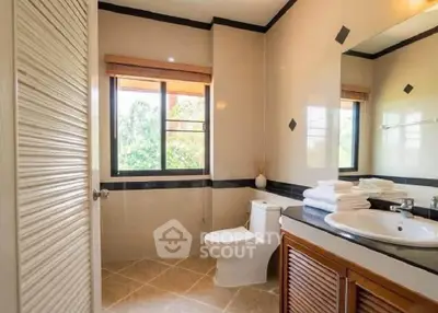Spacious bathroom with modern fixtures and large window offering natural light.