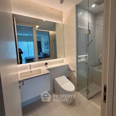 Modern bathroom with glass shower and sleek fixtures in luxury apartment