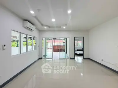 Spacious modern living room with large windows and sleek tile flooring
