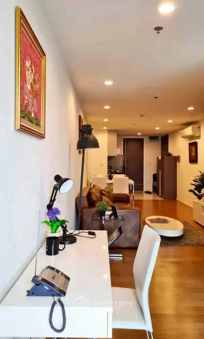 Modern living room with stylish decor and open layout, featuring a cozy workspace and elegant furniture.