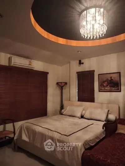 Luxurious bedroom with elegant chandelier and cozy decor