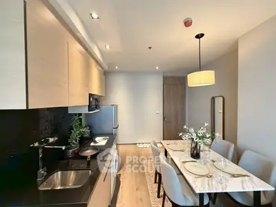 Modern kitchen and dining area with sleek design and elegant lighting, perfect for entertaining guests.